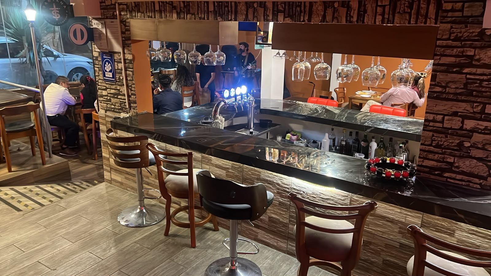 La barra de La Barra Resto Bar con música en vivo al fondo