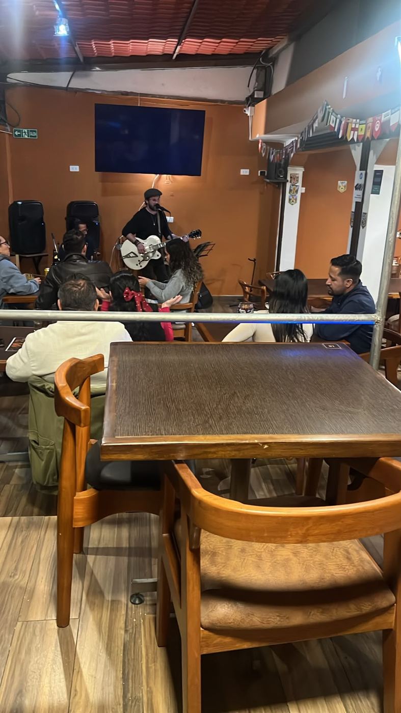 Músico tocando guitarra en la tarima de la planta baja